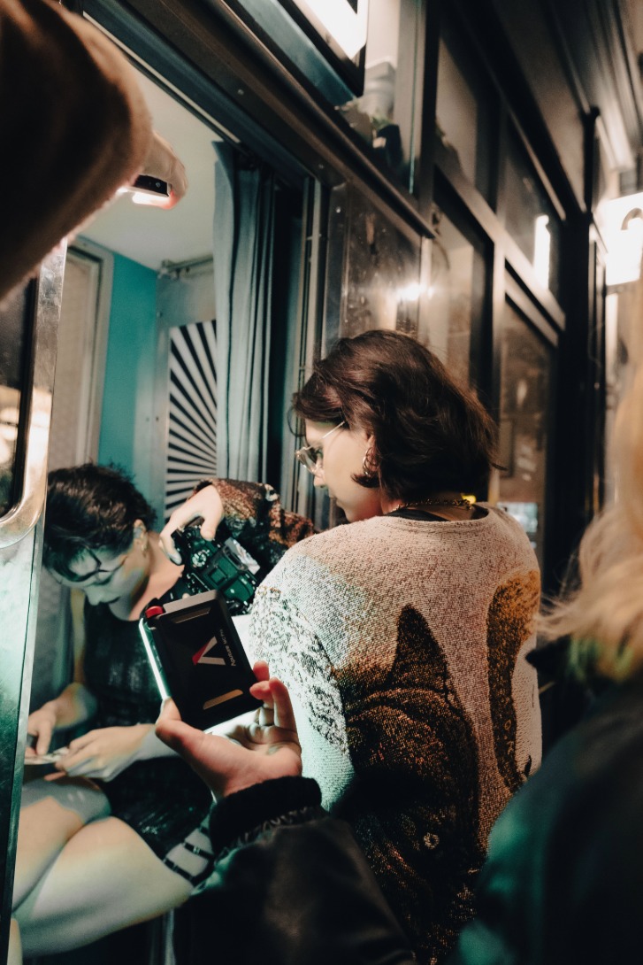 L’équipe filme la mannequin dans une cabine, scène sensuelle et artistique pour le projet Mak Lingerie.