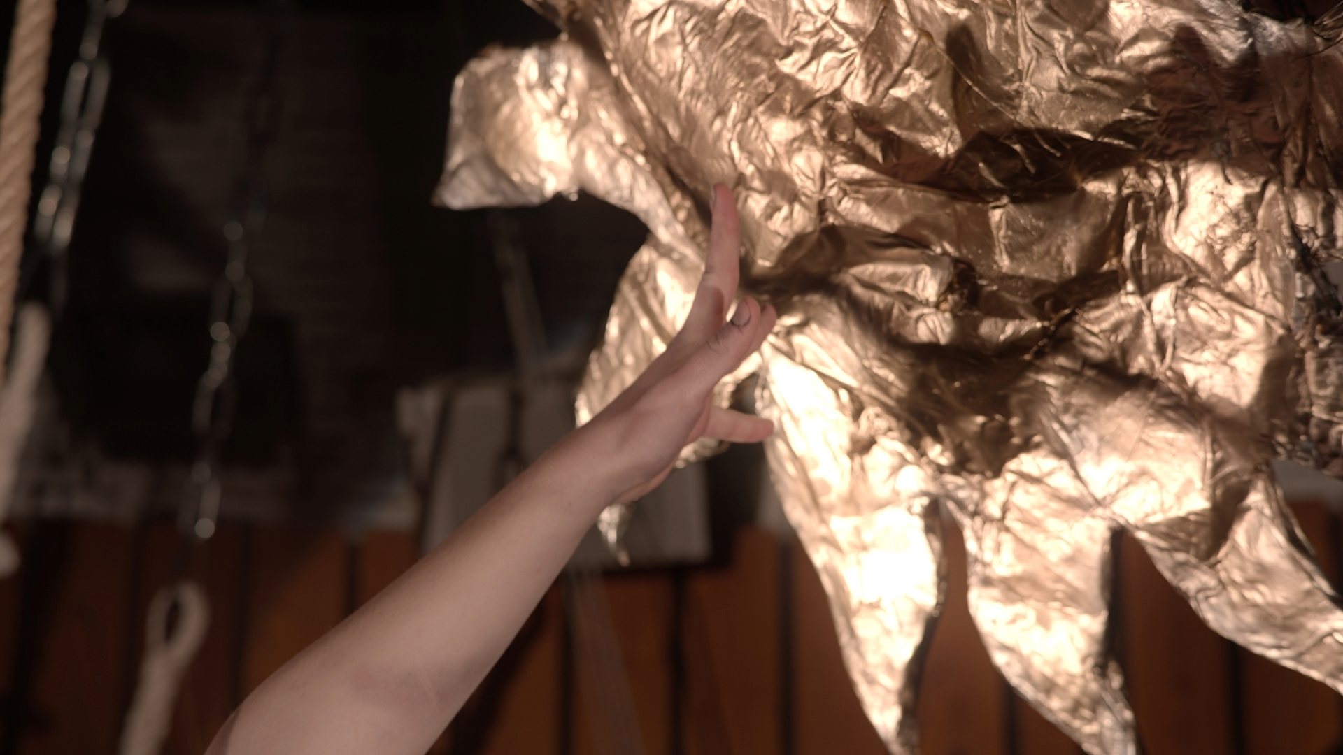 Main tendue vers un décor doré en forme de soleil dans le projet Icare, captée par O3il Production.