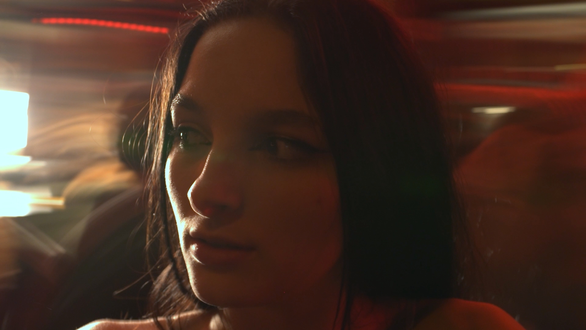 Portrait de l'une des deux femmes du clip Limpide, éclairée par une lumière chaude au milieu de l'agitation.