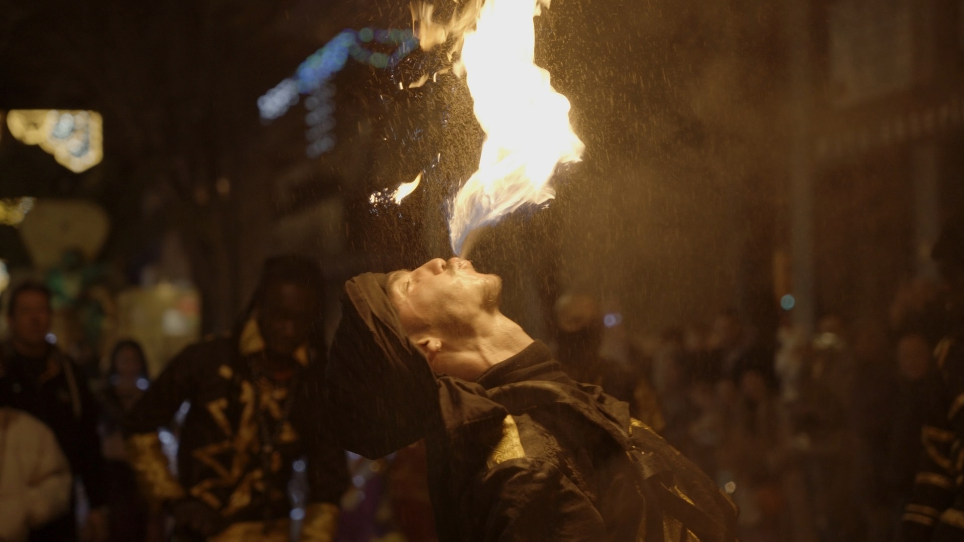 Image tirée du documentaire Embrasés réalisé par O3il Production, montrant un artiste du collectif Imaziren en pleine performance de cracheur de feu lors d'une parade à Figueras, Espagne.