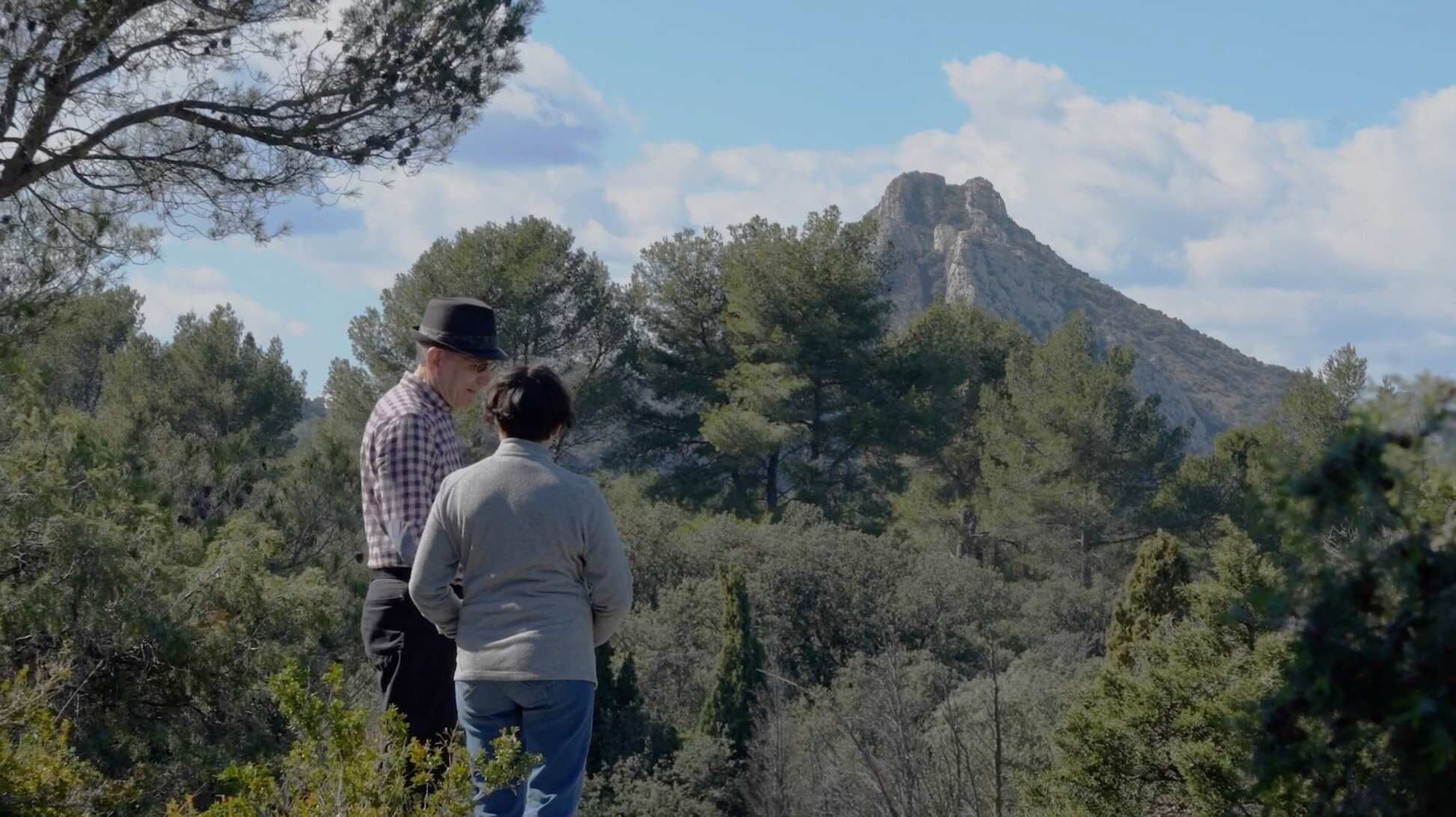 Deux personnes marchant dans un paysage naturel face à une montagne, illustration du projet audiovisuel d’O3il Production dédié à Jean Moulin et à l’association Les Chemins de la Liberté.