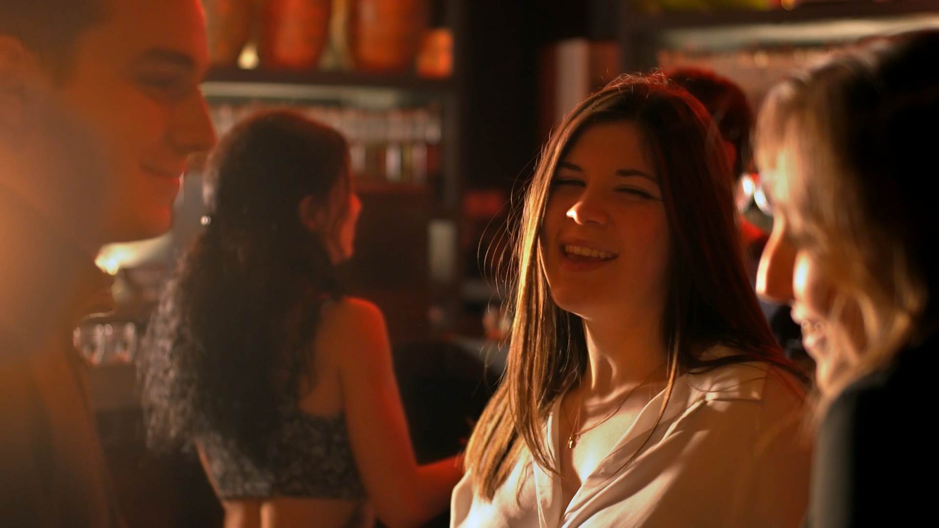 Moment de complicité entre les personnages du clip Limpide, dans l’ambiance chaleureuse d’un bar.