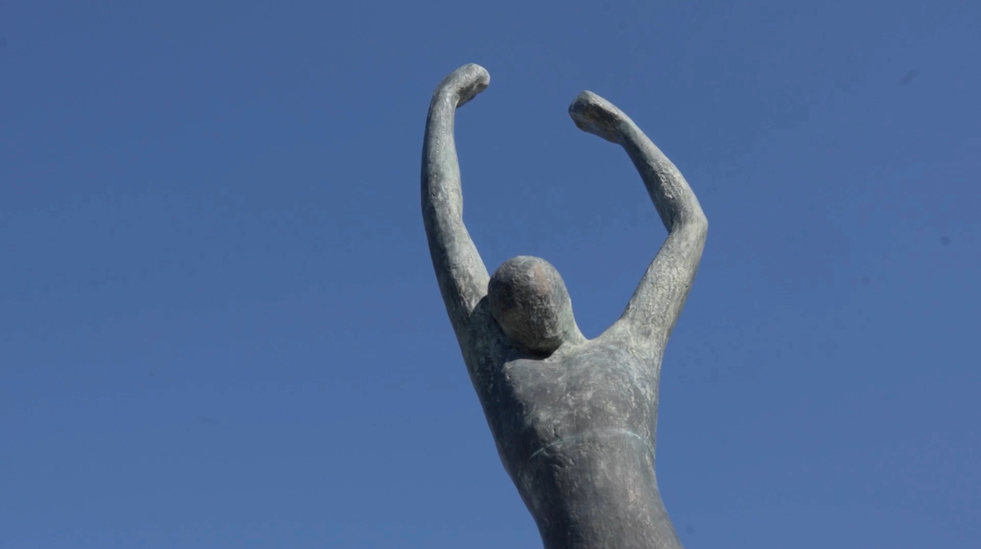 Statue en hommage à Jean Moulin, figure emblématique de la Résistance française, photographiée sous un ciel bleu dans le cadre du projet O3il Production.