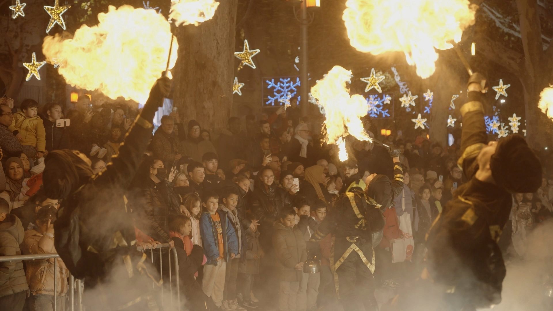 Vue d’ensemble du spectacle de feu d’Imaziren, plusieurs artistes crachant des flammes devant un public captivé.