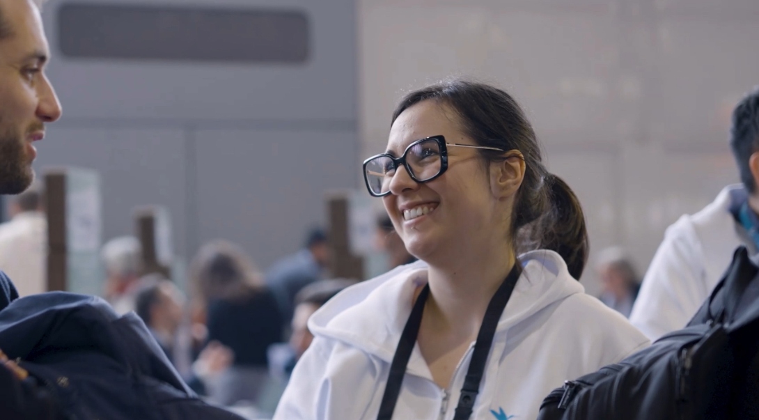 Une membre de l’équipe ZCE échange avec un participant dans l’ambiance conviviale du Tech&Fest 2025, captée par O3il Production.