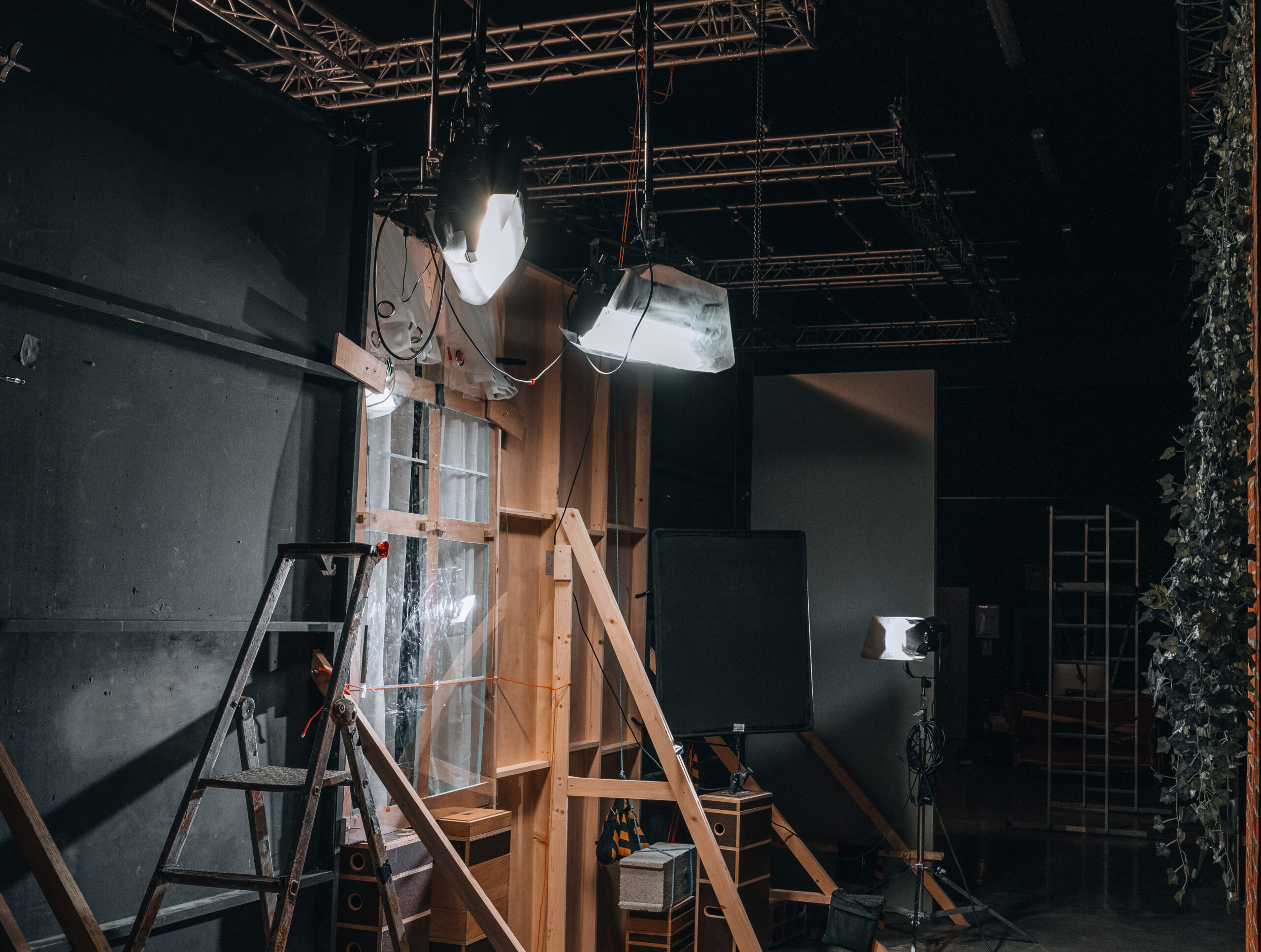 Plateau de tournage en cours d’installation avec projecteurs, échelle et décors en construction – expertise O3il Production.