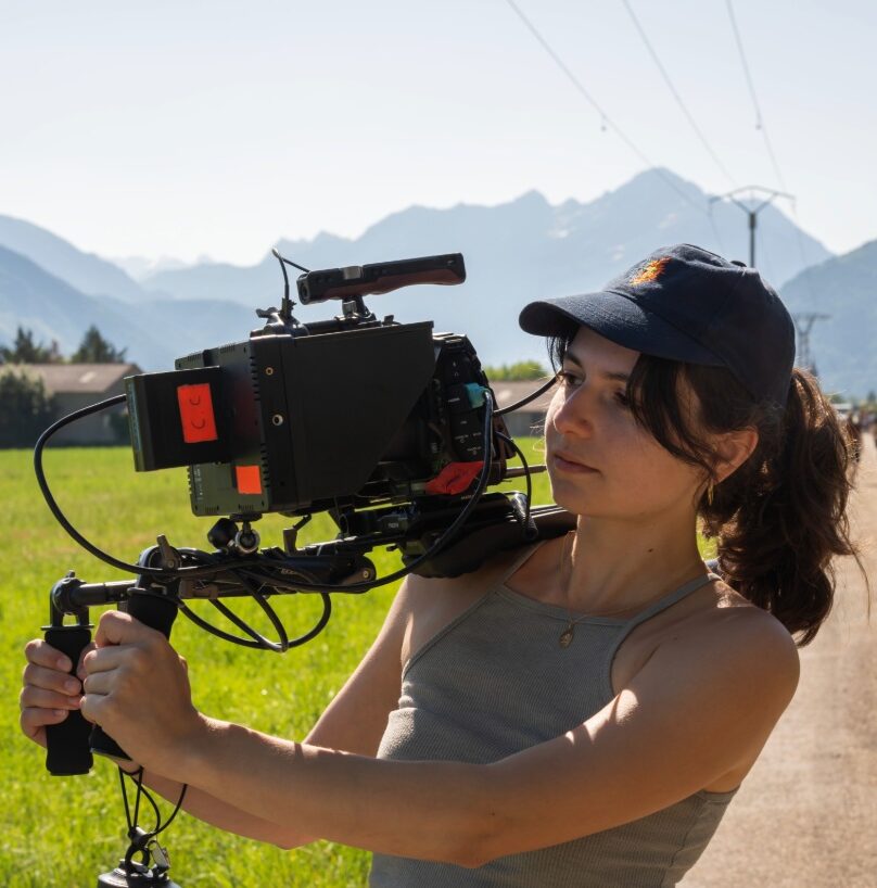 Clémence, productrice et responsable image d’O3il Production, en plein tournage en extérieur avec caméra professionnelle.